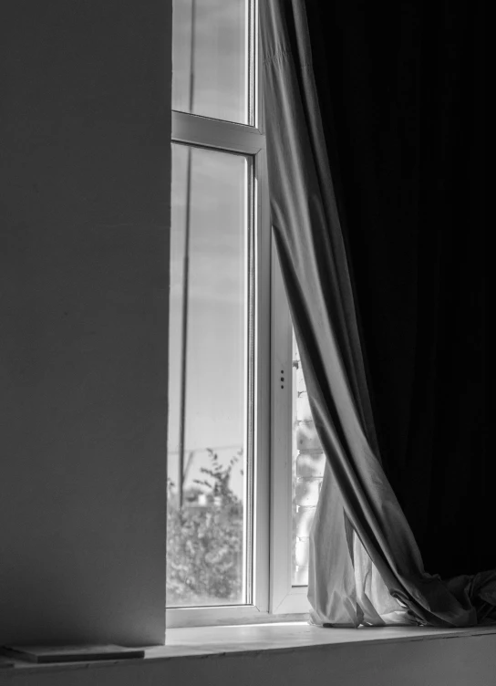 black and white image of a curtain near a window