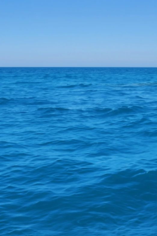 an ocean scene with blue water and clear skies