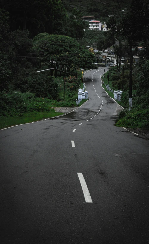 a small, empty street on a hillside with trees