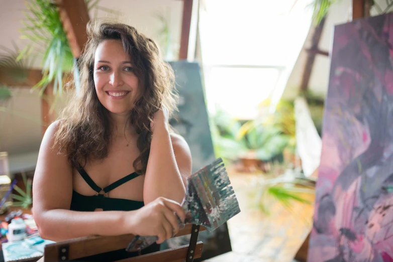 woman standing next to her art work and smiling