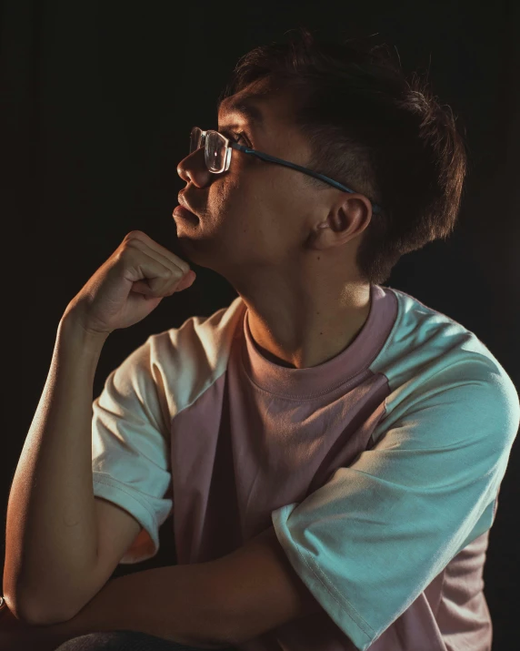 a young man in glasses looks ahead while posing