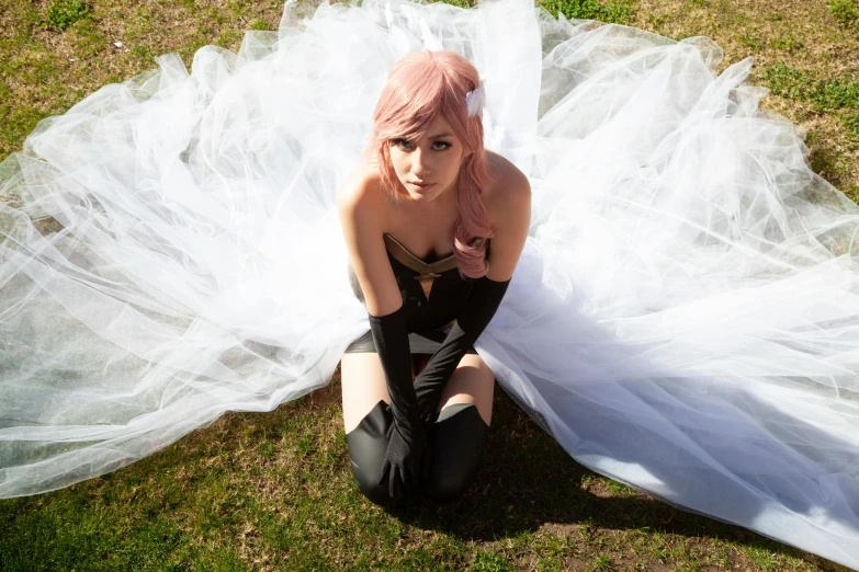 a  is sitting in a white dress and posing for the camera