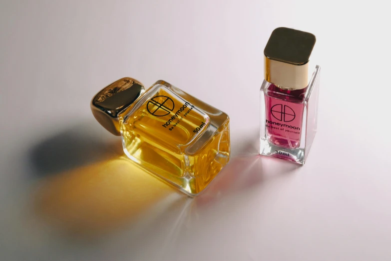 a perfume bottle sitting next to a bottle of oil on a table