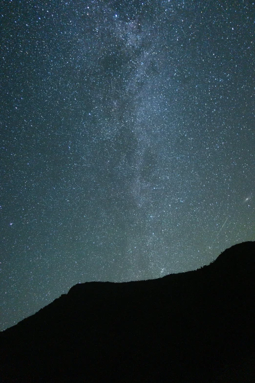 the stars above a mountain in the night