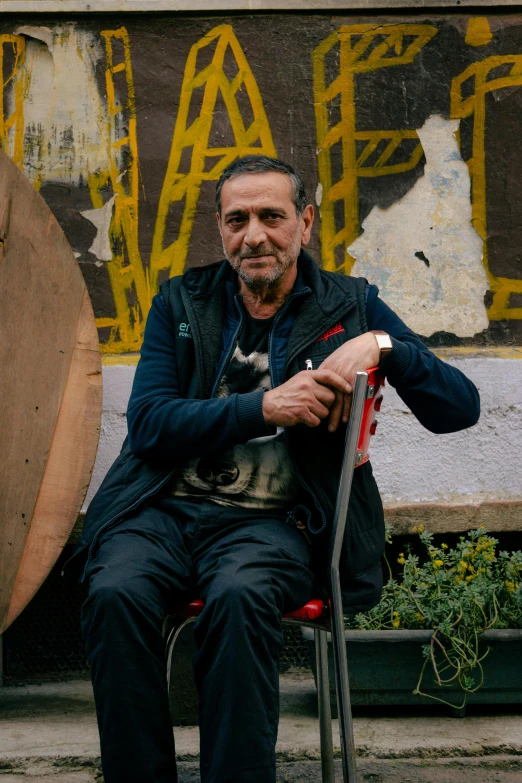 an older man sitting next to a wooden object