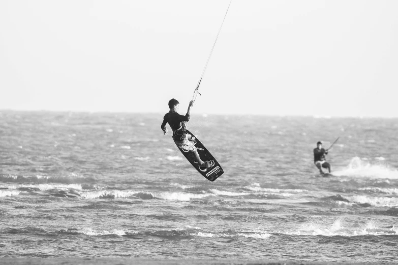 a person on a surfboard holding a para sail on the water