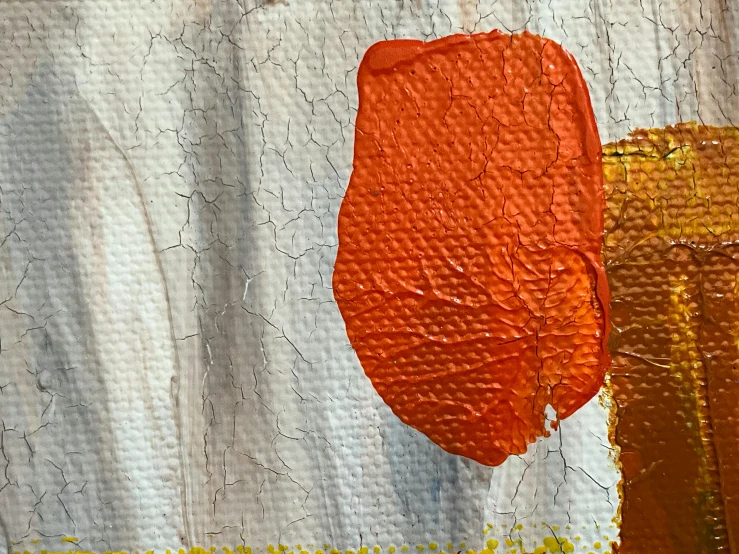 an orange painted piece on a white cloth