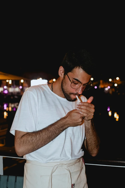 a man standing outside in the dark and smoking soing