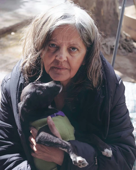 the woman is holding her black cat in her arms