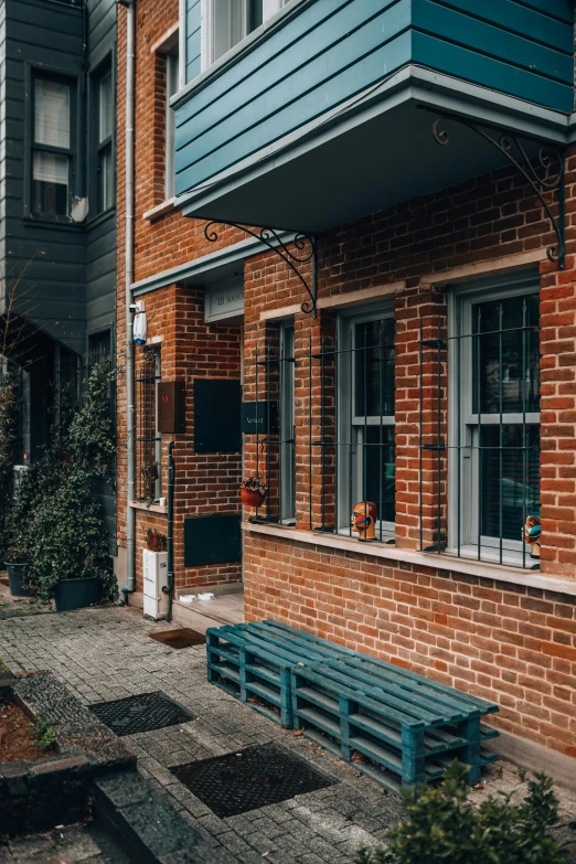 a bench near a house with several windows