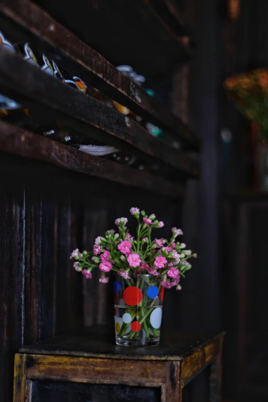 flowers and decorations are in the middle of a vase on an old table