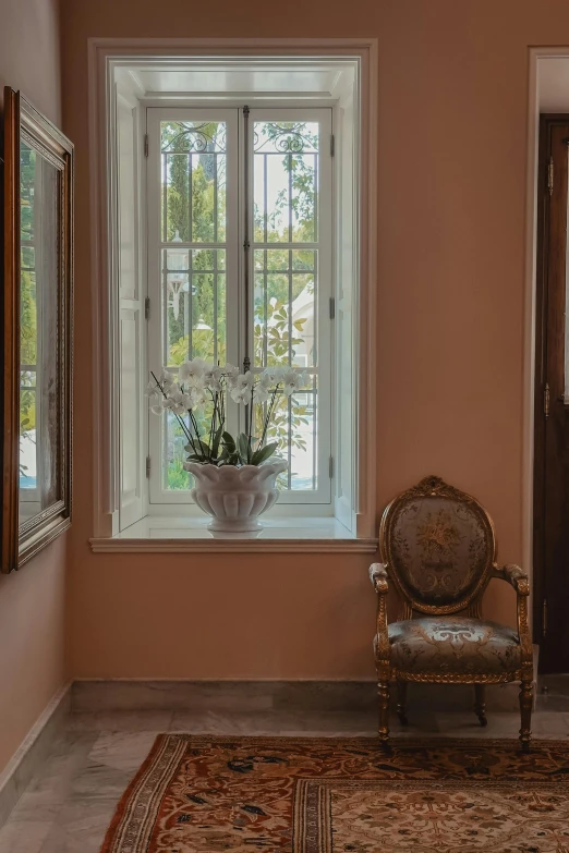 a chair with flowers in it, by a window