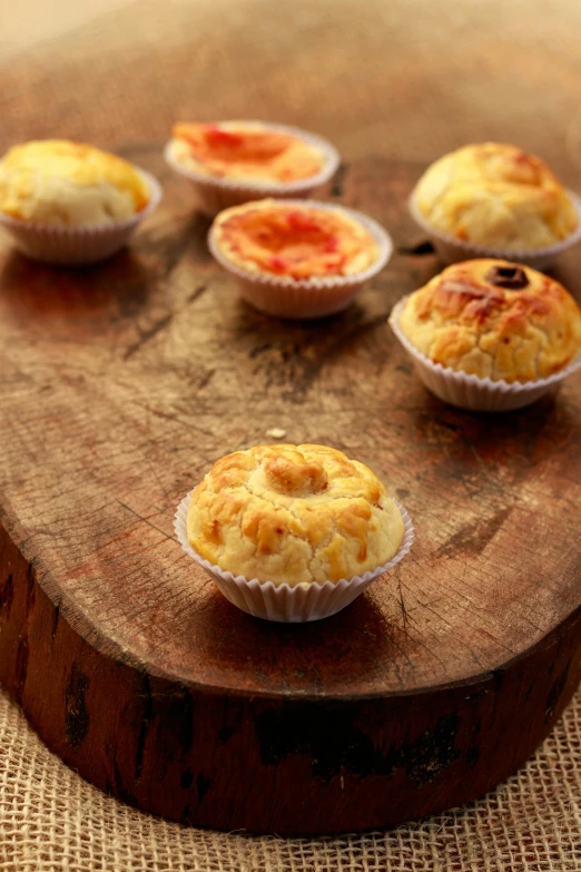 a table topped with muffins on top of a wooden board