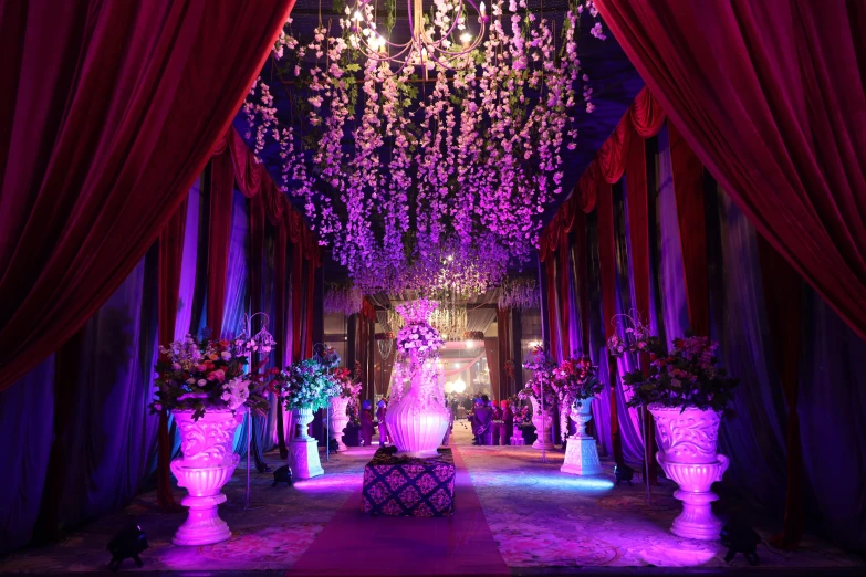 a lavishly decorated hallway is set with pink, purple and green decorations