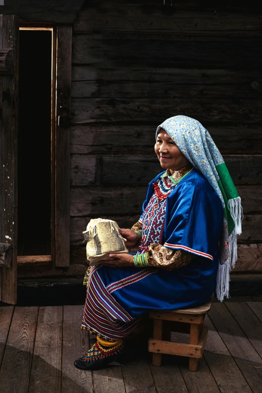 woman in native clothing sitting in wooden outdoor chair