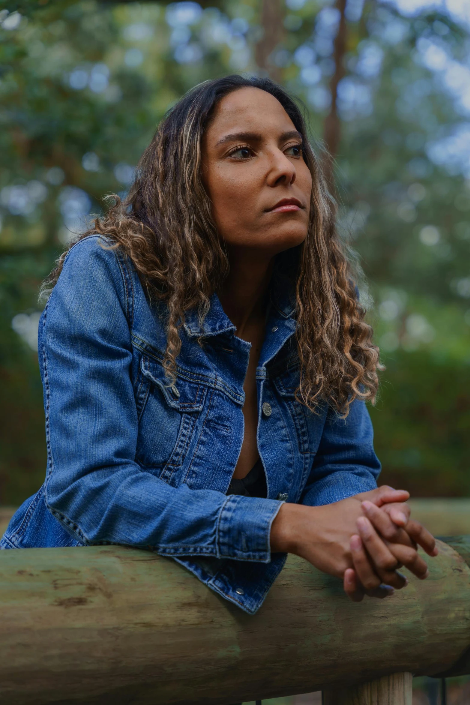 a woman sits on a rail while posing