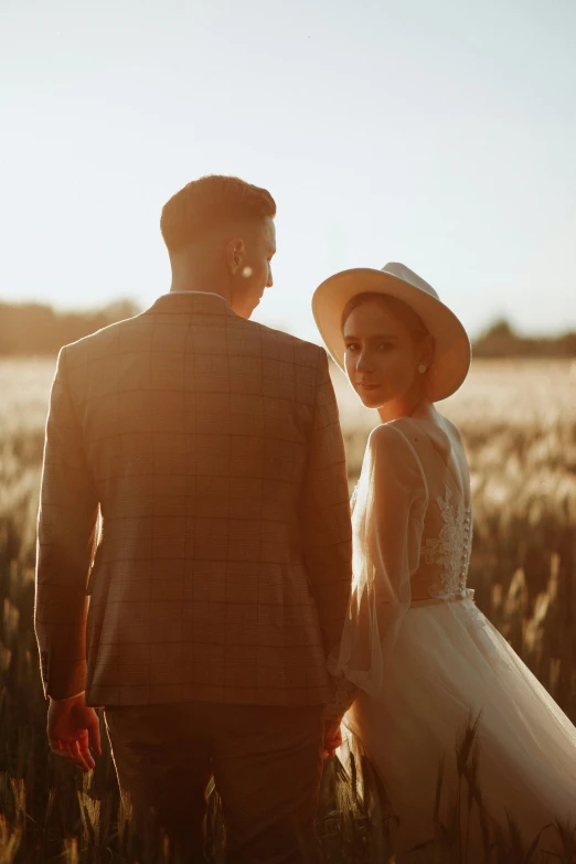 man and woman wearing wedding dresses standing in the sun