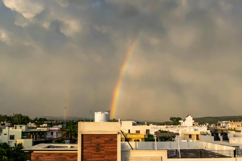 a rainbow in the sky over a city with buildings