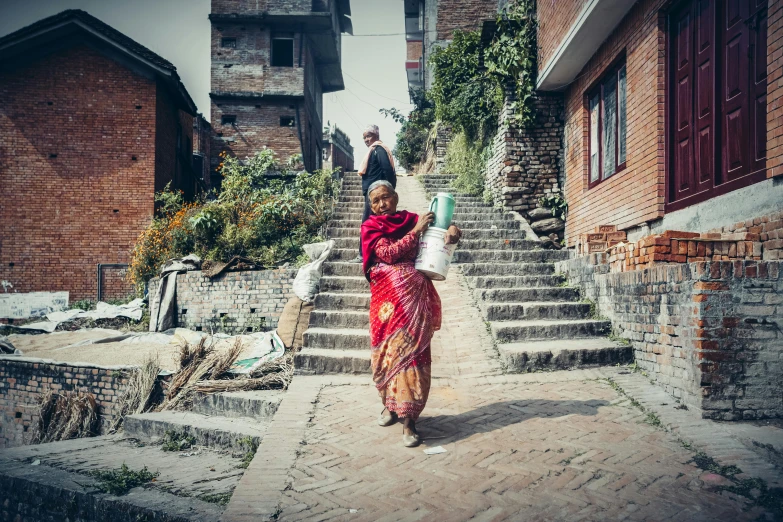 the woman is carrying a drink along the stairs