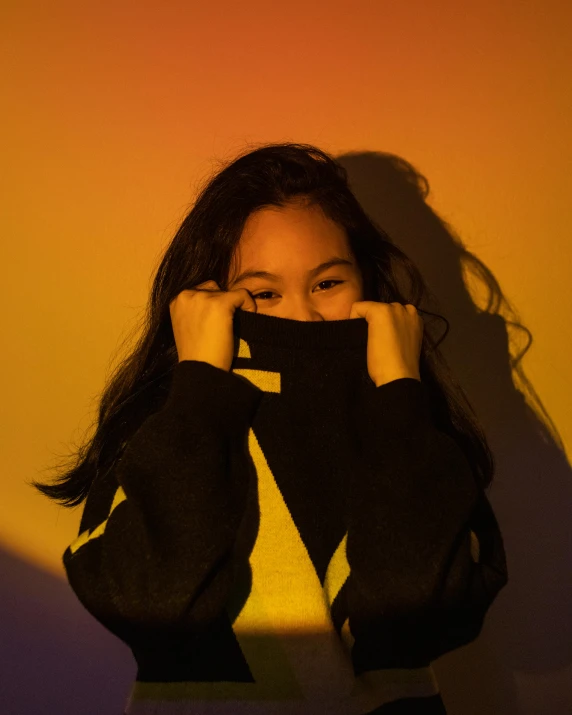 a person in a black top is covering their face with her hands