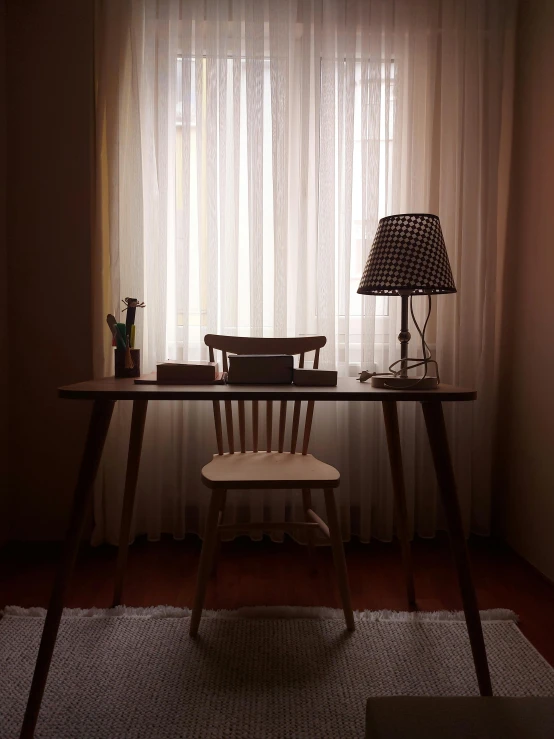 a room that has a light in it and two desks near the window