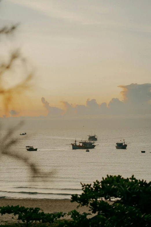 there are several boats in the water off of the beach