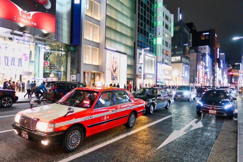 city street scene at night with cars, lights and billboards