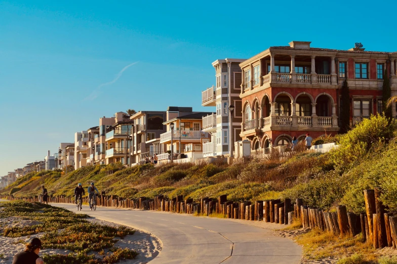 an empty pathway leads to many multi - story buildings on a hill