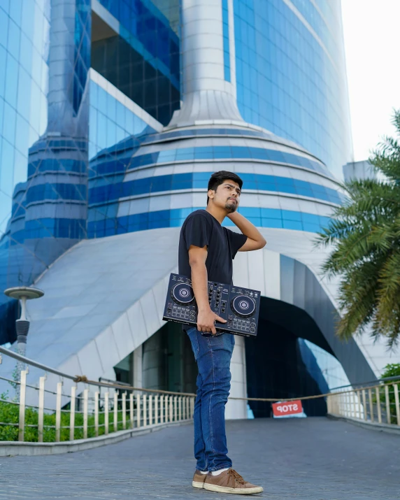 the man is standing in front of the tall building with a handbag