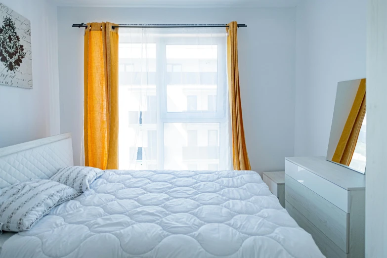 white bedroom with bright yellow ds and a mirror