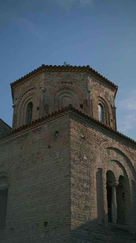 the side of an old stone building with a clock at the top