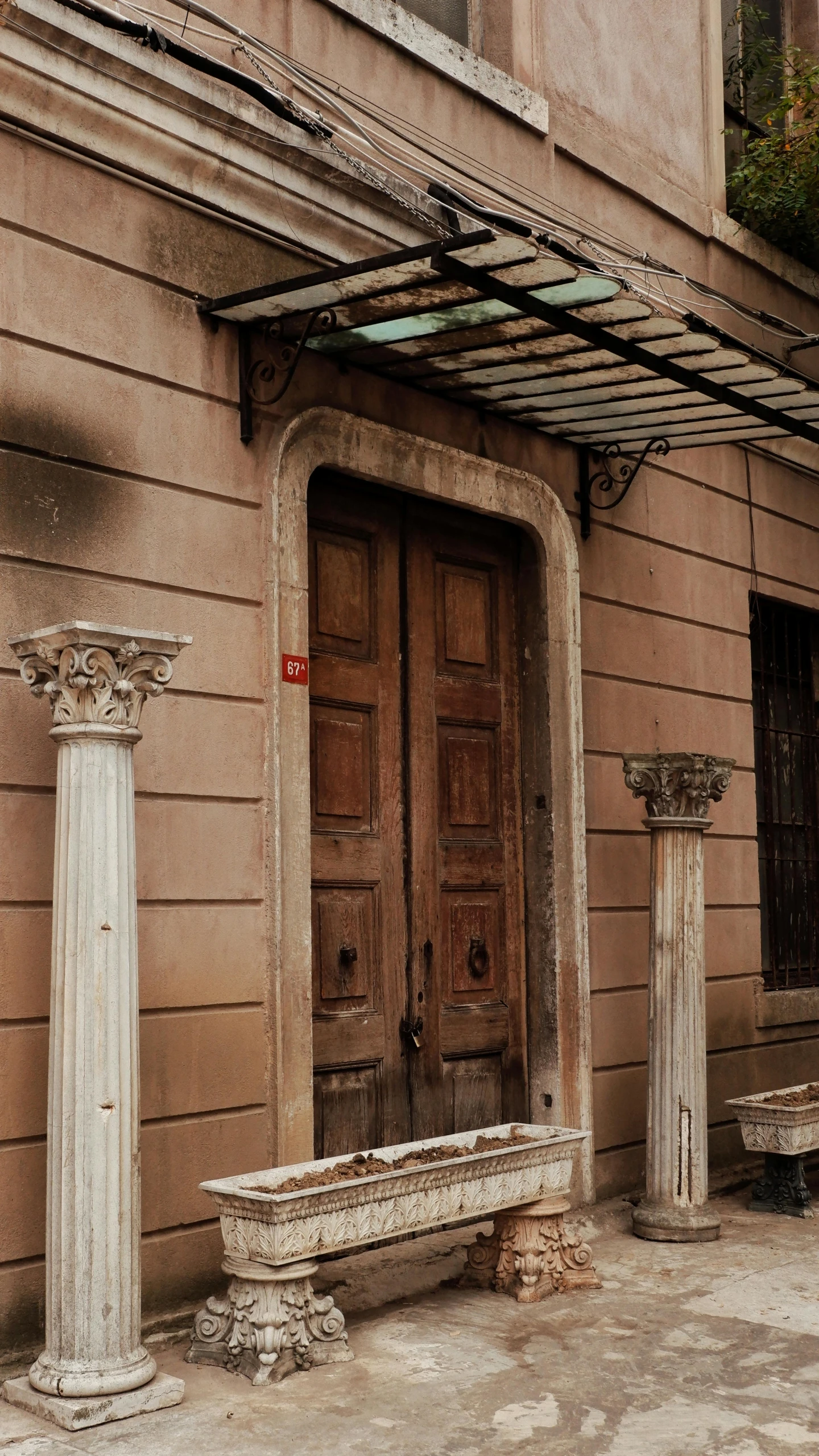 a very old building with two doors and a bench