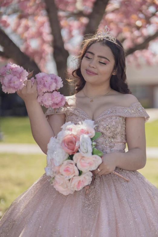 a woman is in a gown holding flowers