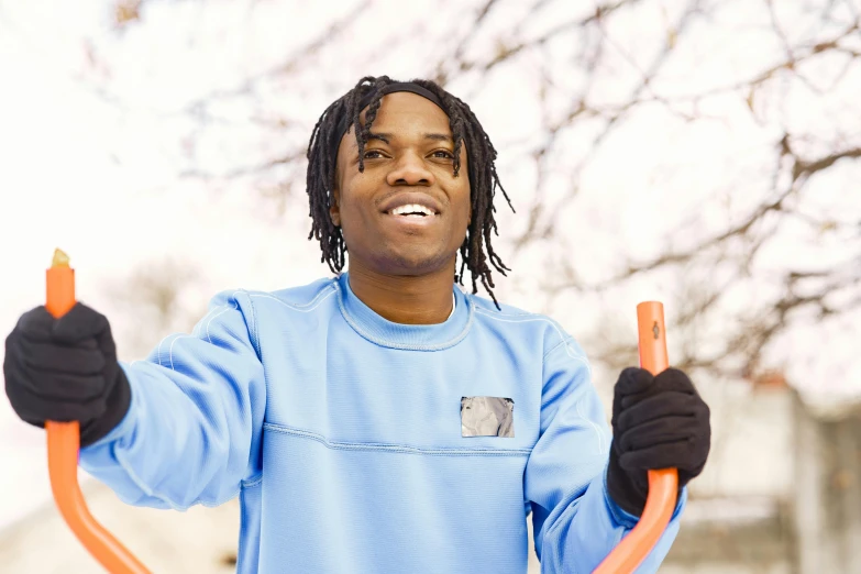 man holding an orange hose to keep his eyes closed