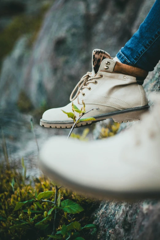 a person standing on top of some rocks with shoes