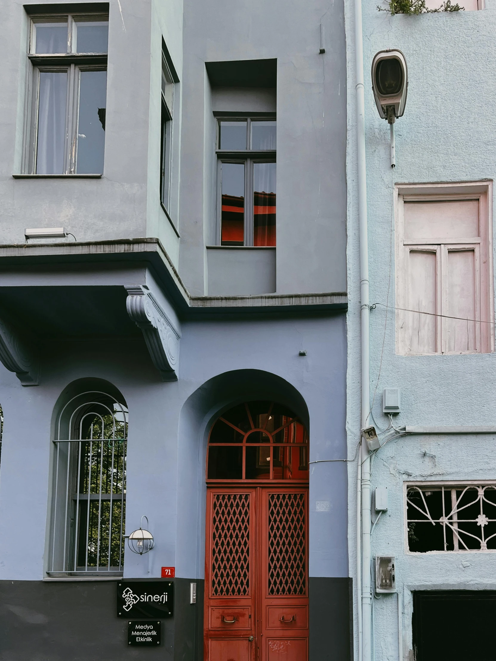 an orange door stands on the corner of two buildings