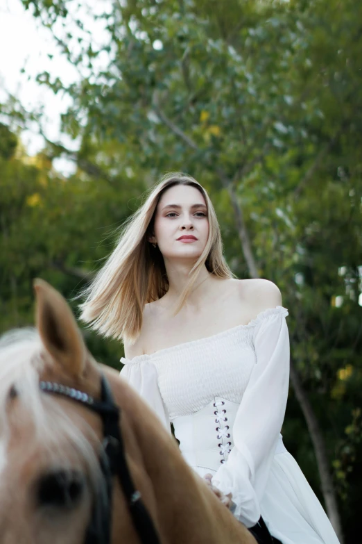 a woman with blonde hair is riding on a horse