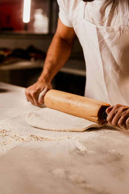 a man rolling dough on a counter