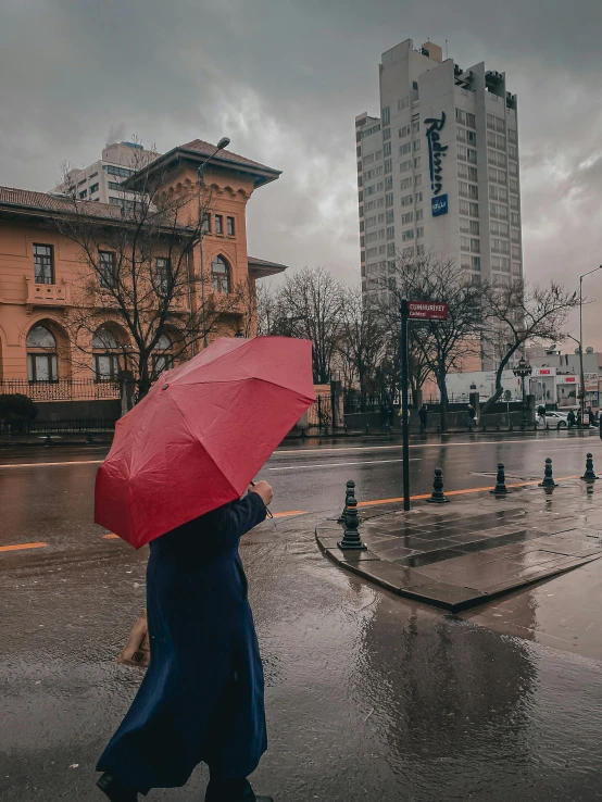 a person holding an umbrella is walking on a rainy street