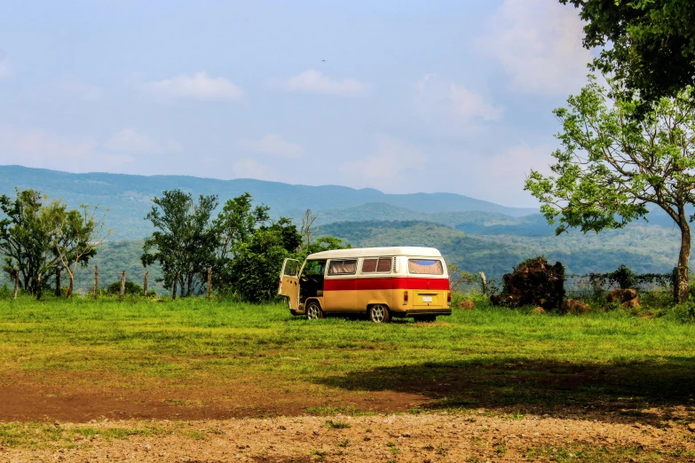 a small white and red bus on a grassy field