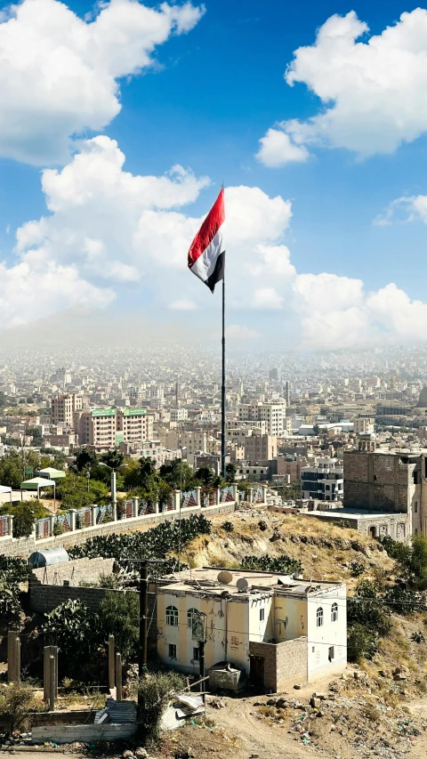 a flag flying over an old building on top of a hill