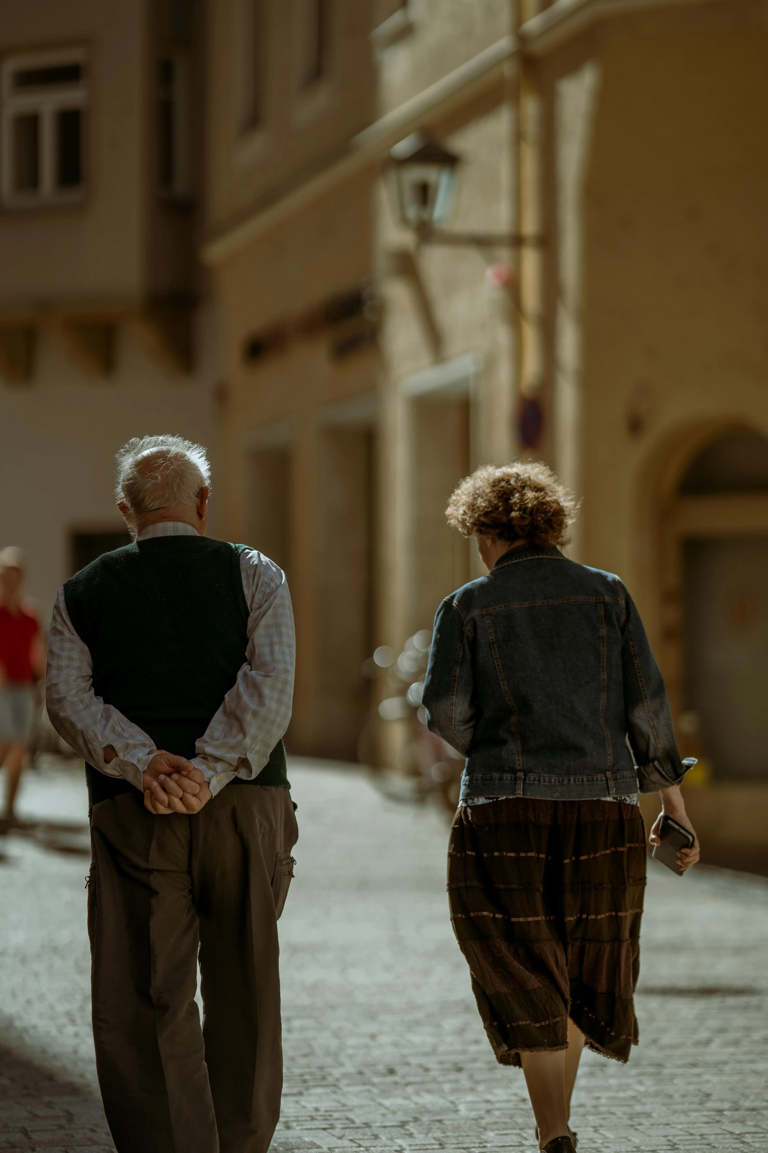 two people are walking down a street together