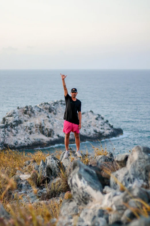 a person standing on a rock by the water