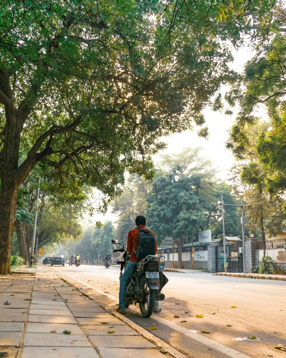 the man rides his motorcycle down the street