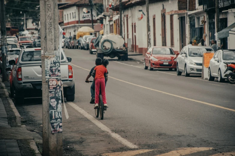 a person riding a bike down a street near other cars