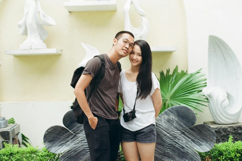 a couple is posing in front of some art work