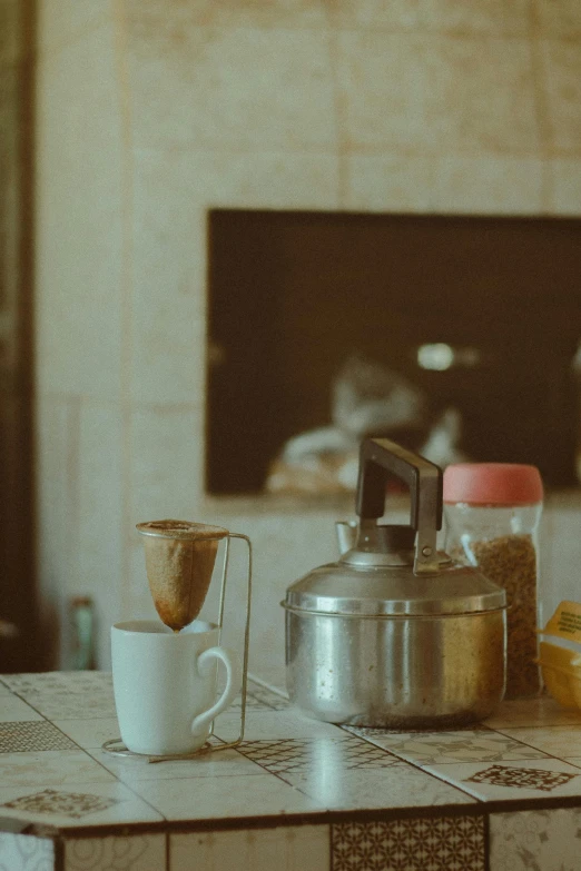 a coffee pot sitting on top of a tile counter