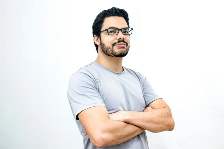 a man posing with his arms crossed in front of a white background