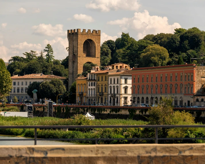 several buildings on a hill with a clock tower in the distance