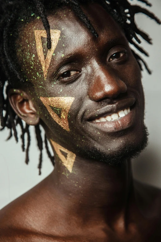 a man with green and gold face paint